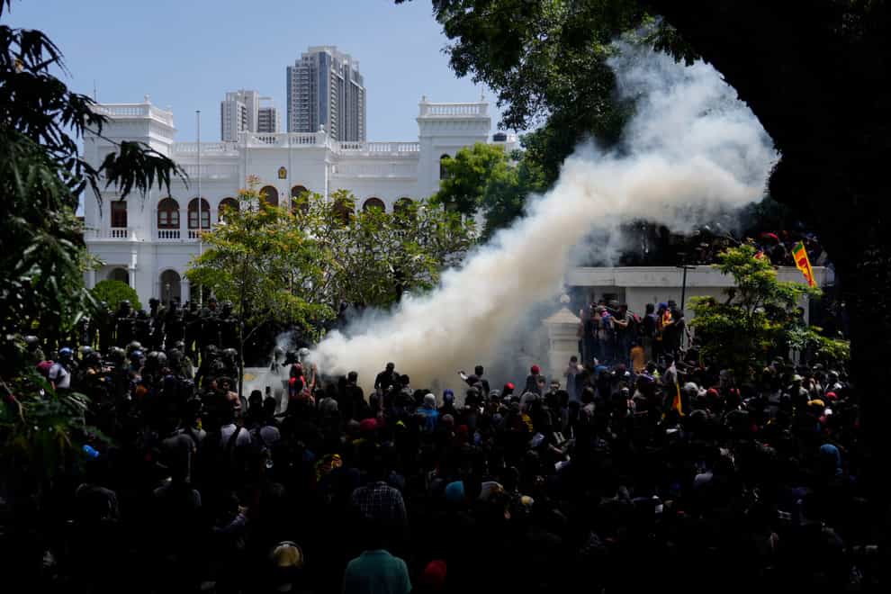 Sri Lankan protesters storm the compound of prime minister Ranil Wickremesinghe’s office (Rafiq Maqbool/AP)