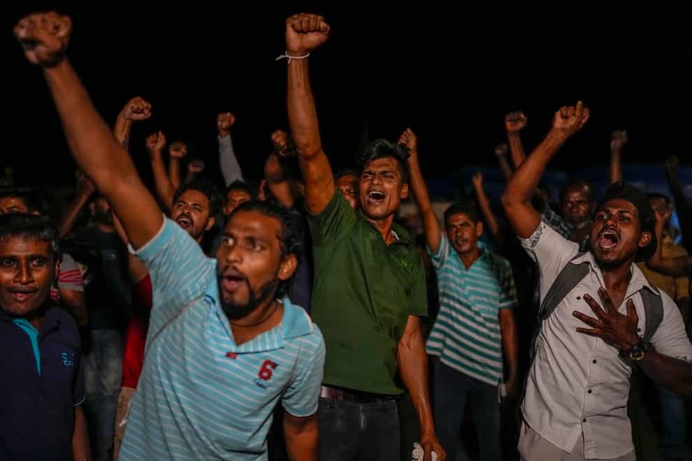 Sri Lankans celebrate as they react to early reports of President Gotabaya Rajapaksa’s resignation in Colombo (AP)