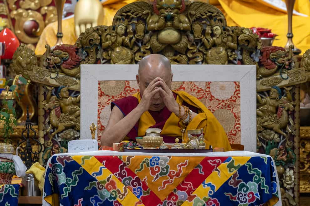 Tibetan spiritual leader the Dalai Lama prays during a religious talk at the Tsuglakhang temple in Dharmsala, India (AP)