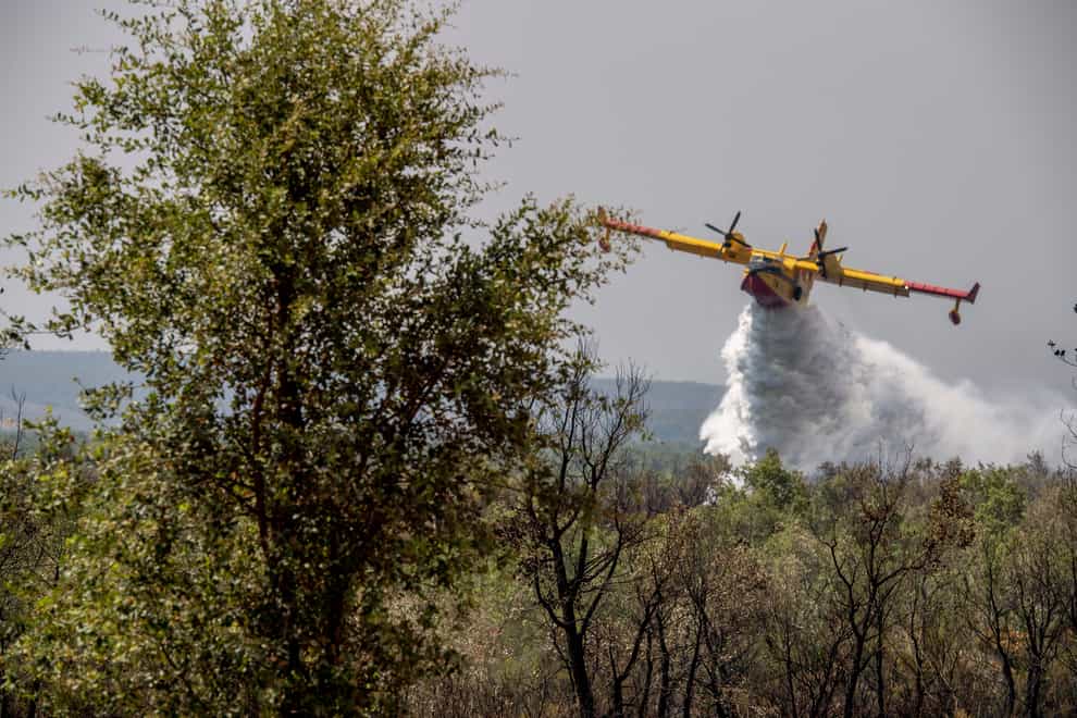 Firefighting planes drop water to put out a forest blaze in Laarache, northern Morocco (AP)