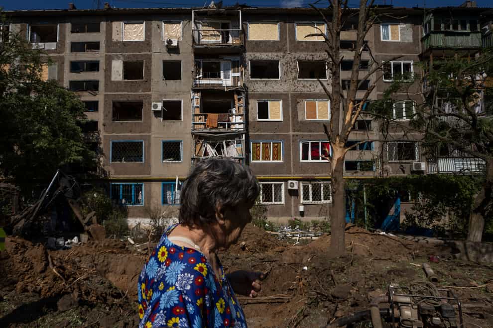 A woman walks past a damaged building in the aftermath of a missile strike in Konstantinovka, in Donetsk Oblast, eastern Ukraine, Friday, July 15, 2022. (AP Photo/Nariman El-Mofty)