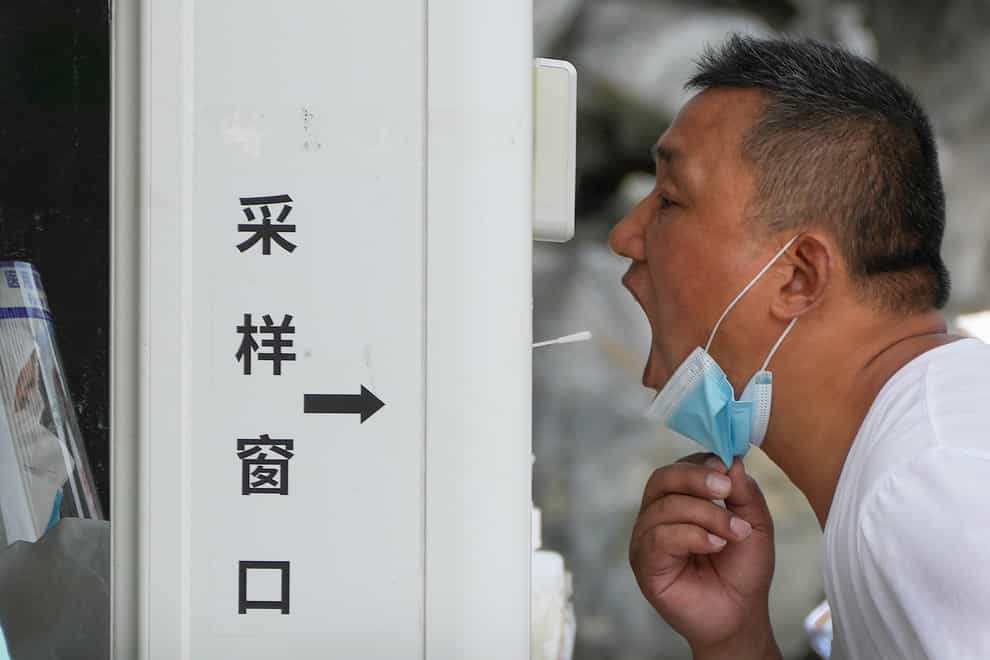 A man gets a throat swab at a testing site (Andy Wong/AP)