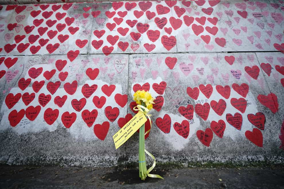 Flowers by the Covid memorial wall in London (Yui Mok/PA)