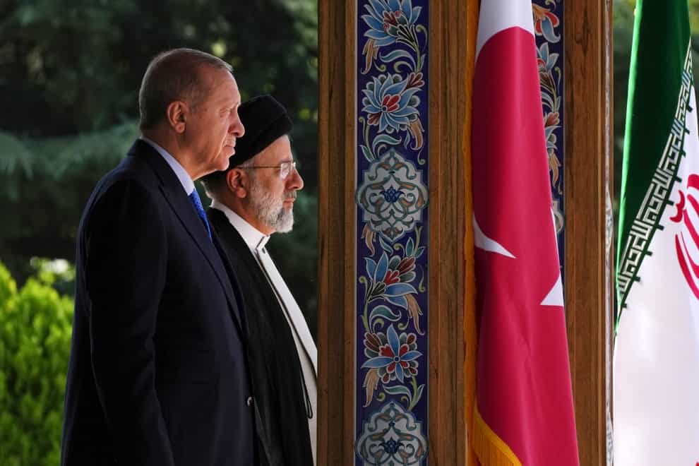 Turkish President Recep Tayyip Erdogan, left, and his Iranian counterpart Ebrahim Raisi listen to their countries’ national anthem during the welcoming ceremony at the Saadabad palace, in Tehran, Iran, Tuesday, July 19, 2022 (Vahid Salemi/AP/PA)