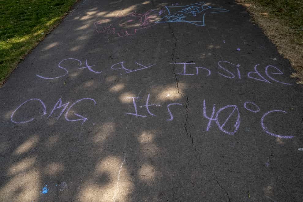 Writing on the ground in Sandall Park, Doncaster that reads “stay inside OMG it’s 40C” (Danny Lawson/PA)