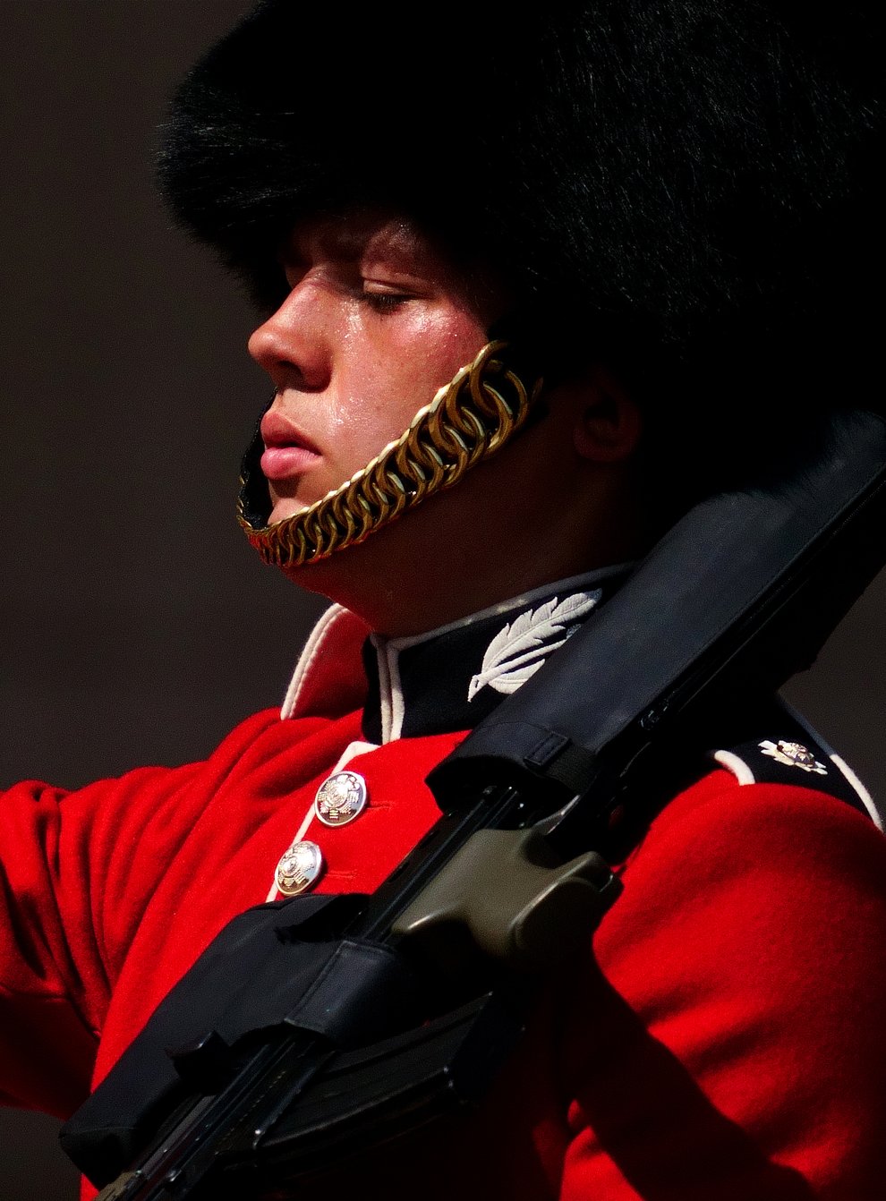 A member of F Company Scots Guards swelters in the heat during the Changing of the Guard ceremony on the forecourt of Buckingham Palace (Victoria Jones/PA)