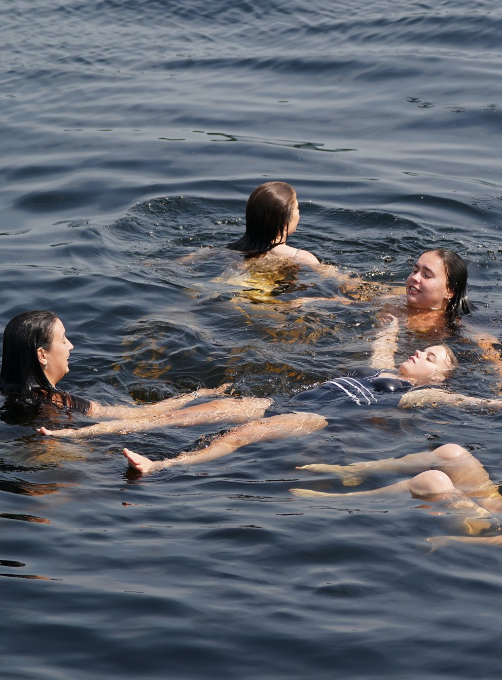 Girls take a dip to cool off in the waters of Loch Lomond at Luss (Andrew Milligan/PA)