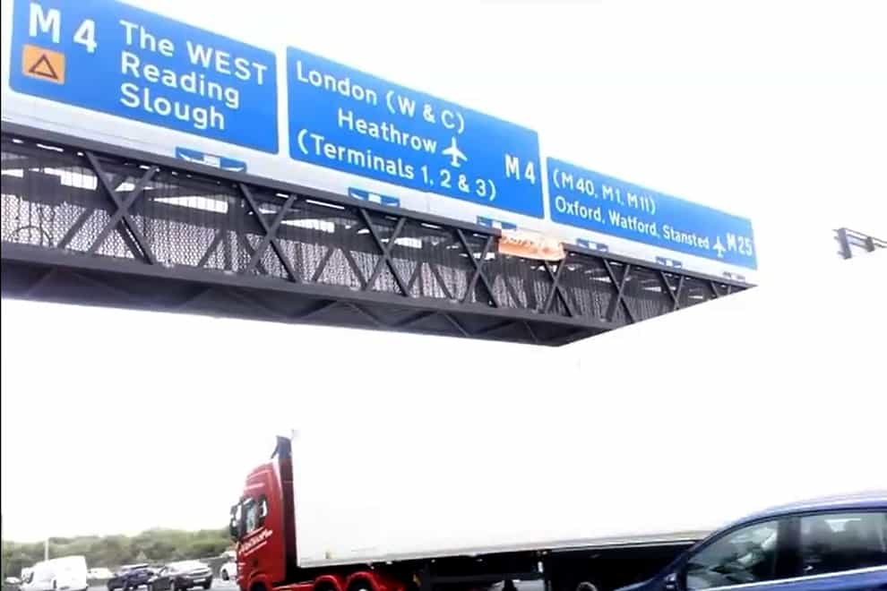 A group of Just Stop Oil activists who have climbed motorway signs on the M25 (Screengrab/Just Stop Oil/PA)