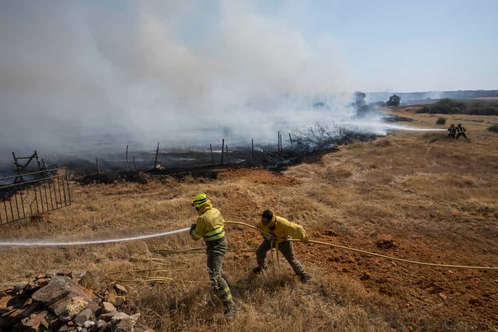 Firefighters work at the scene of a wildfire in Tabara, north-west Spain, Tuesday, July 19, 2022 (Bernat Armangue/AP/PA)