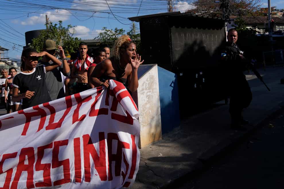 Residents gather to protest against the police operation (Silvia Izquierdo/AP)