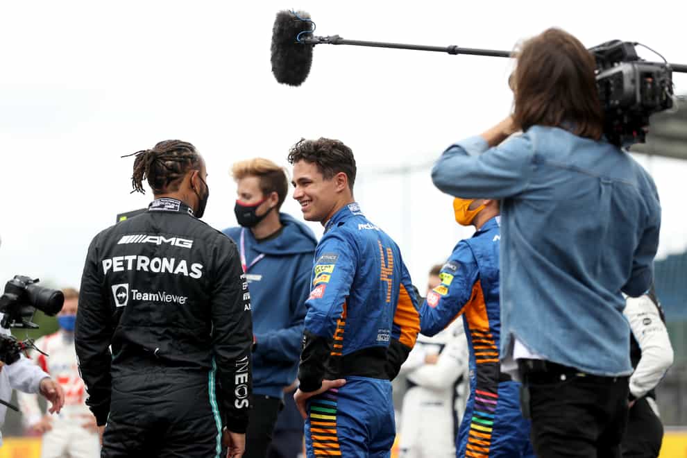 Lewis Hamilton, left, talks with Lando Norris in the paddock ahead of the British Grand Prix (Bradley Collyer/PA)