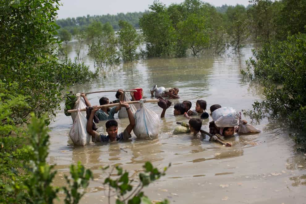 A Rohingya family reaches the Bangladesh border in 2017, after crossing a creek. Judges at the International Court of Justice rule Friday July 22, 2022, on whether a case brought by Gambia alleging that Myanmar is committing genocide against the Rohingya can go ahead. Myanmar argues that the court does not have jurisdiction (Bernat Armangue/AP/PA)