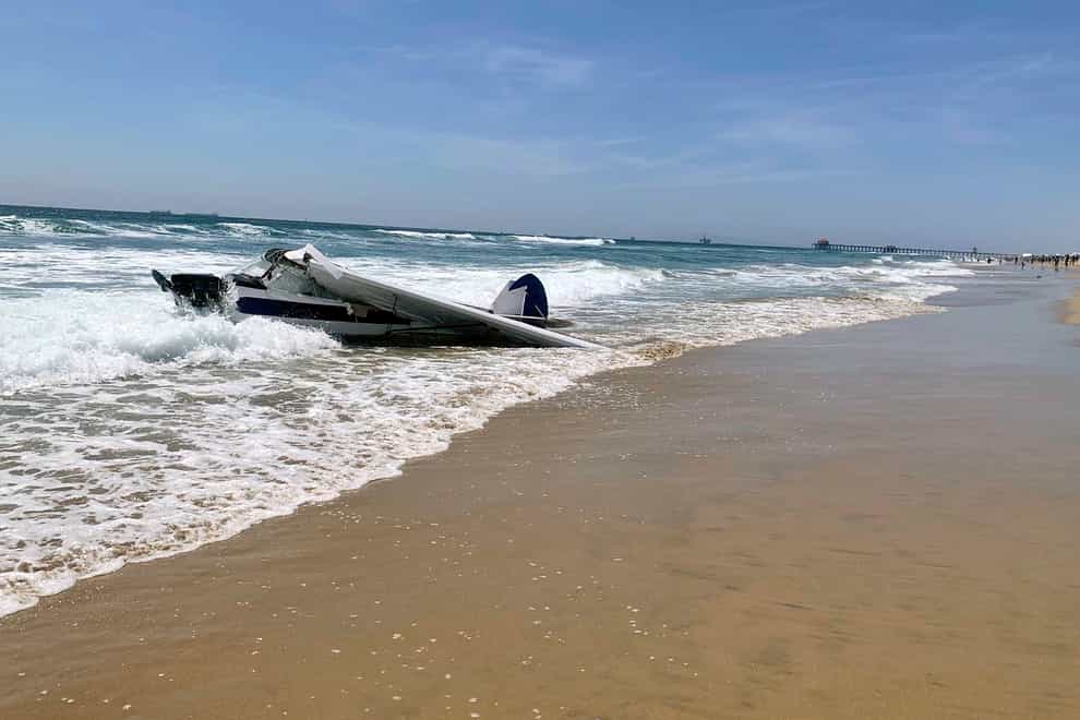 The small plane sits in the surf after it crashed into the sea just off Huntington Beach, California (Huntington Beach Fire Department/AP)