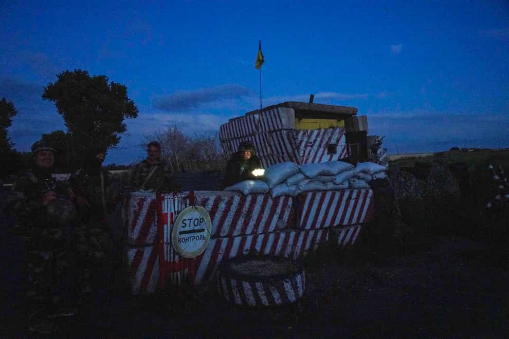 Ukrainian servicemen stand guard at a checkpoint in Donetsk, eastern Ukraine (Nariman El-Mofty/AP)