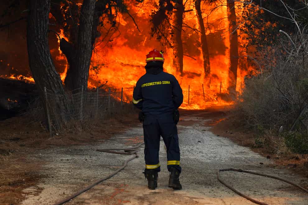 A firefighter tries to extinguishes a forest fire near the beach resort of Vatera, on the eastern Aegean island of Lesbos (AP)