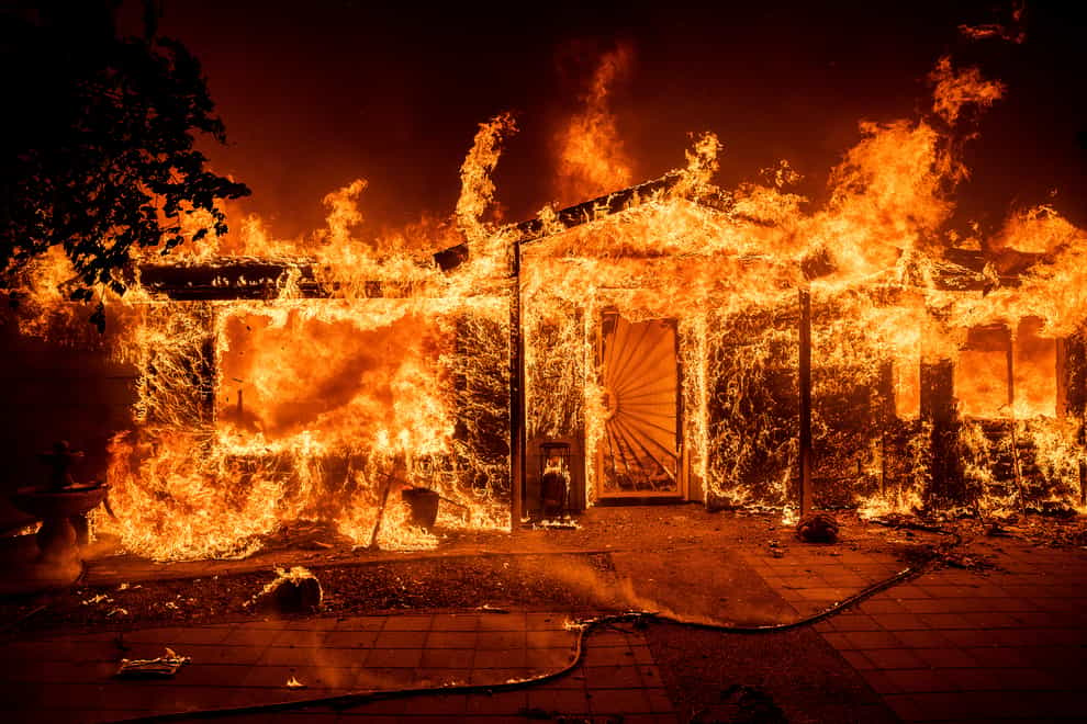 Flames consume a home on Triangle Road as the Oak Fire burns in Mariposa County (AP)