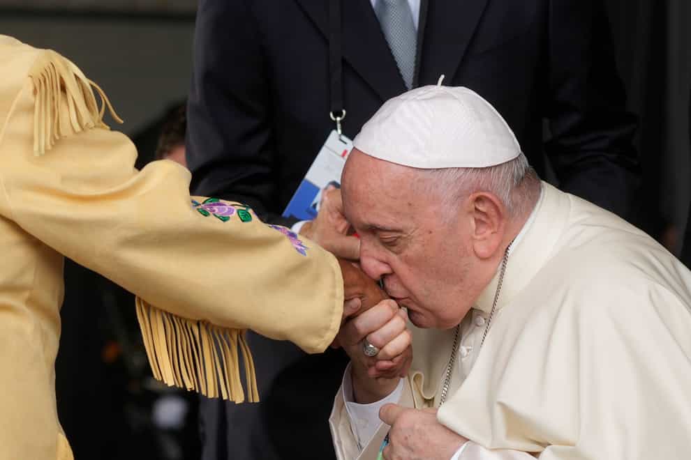 Pope Francis kisses the hand of a Canadian Indigenous woman as he arrives at Edmonton’s International airport (AP Photo/Gregorio Borgia)