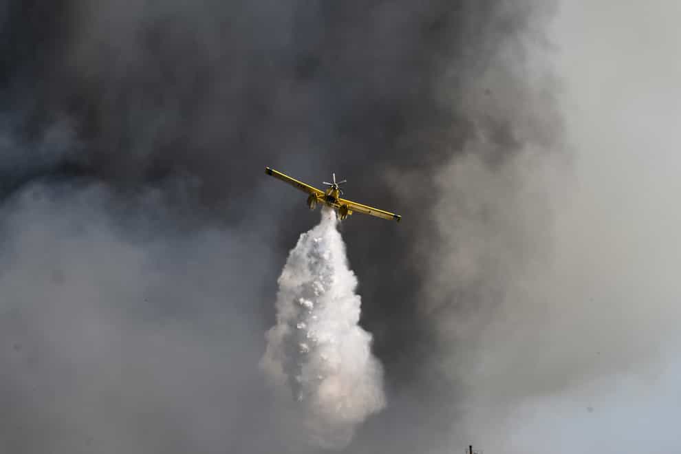 A firefighting plane throws water near the village of Krestena south of Ancient Olympia (ilialive.gr via AP)