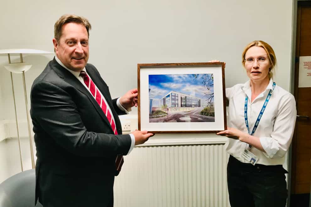 South Eastern Health and Social Care Trust acting chairman Jonathan Patton is presented with a painting of the new inpatient ward block at the Ulster Hospital by its artist, Dr Jennifer Elder (South Eastern HSC Trust/PA)