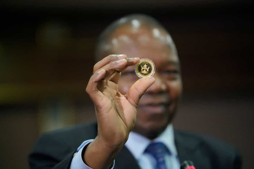 Reserve Bank of Zimbabwe Governor, John Mangudya holds a sample of a gold coin at the launch in Harare, Monday, July, 25, 2022.Zimbabwe has launched gold coins to be sold to the public in a bid to to tame runaway inflation that that has further eroded the country’s unstable currency (Tsvangirayi Mukwazhi/AP/PA)