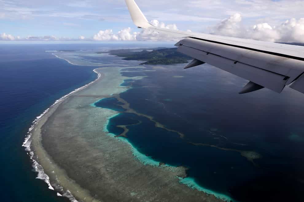 A plane flies over Kolonia, in Federated States of Micronesia (Jonathan Ernst/Pool Photo via AP, File)