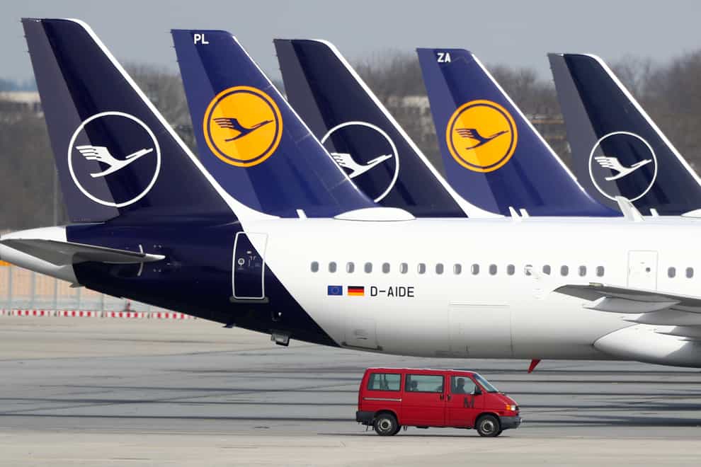 Lufthansa planes sit parked in a line at the airport in Munich, Germany (Matthias Schrader/AP)