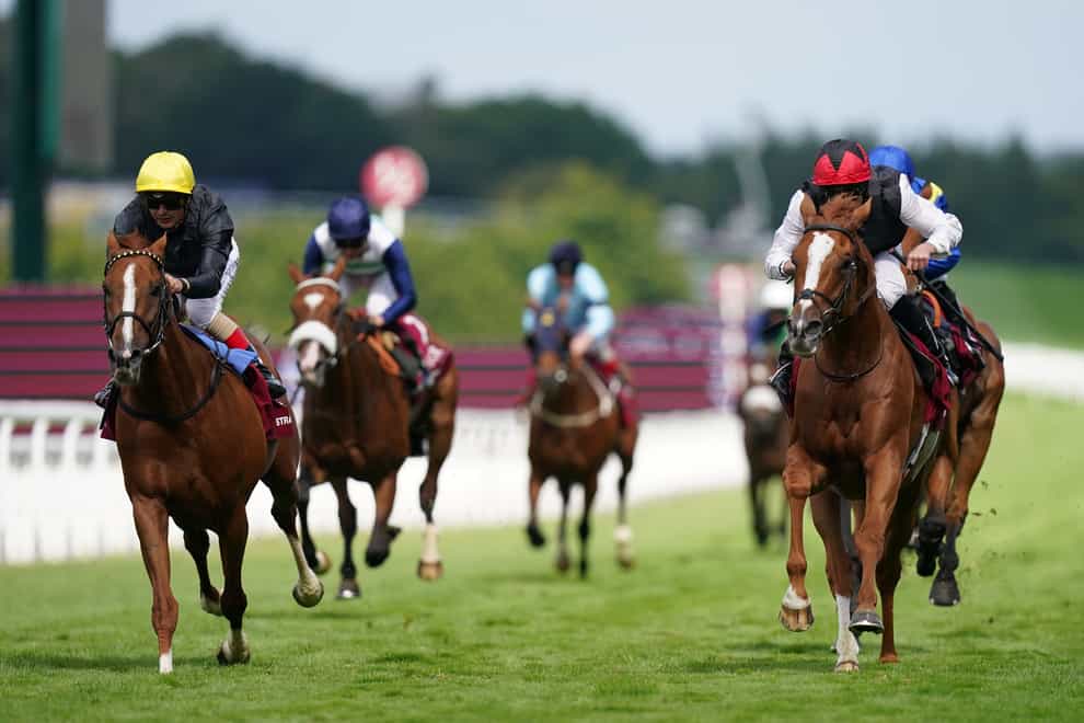 Kyprios ridden by Ryan Moore (right, red helmet) passes Stradivarius ridden by Andrea Atzeni (left, yellow helmet) on their way to winning the Al Shaqab Goodwood Cup Stakes on day one of the Qatar Goodwood Festival 2022 at Goodwood Racecourse, Chichester. Picture date: Tuesday July 26, 2022.