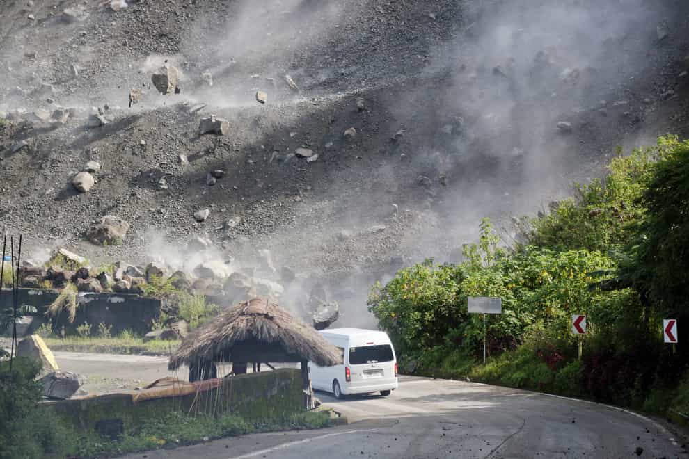 Boulders fall as a vehicle negotiates a road during an earthquake in Bauko, Mountain Province, Philippines (AP)