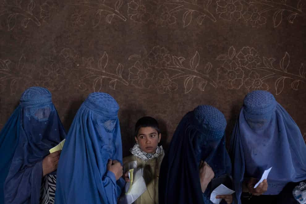 Afghan women wait to receive cash at a money distribution point organised by the World Food Programme in Kabul (AP)