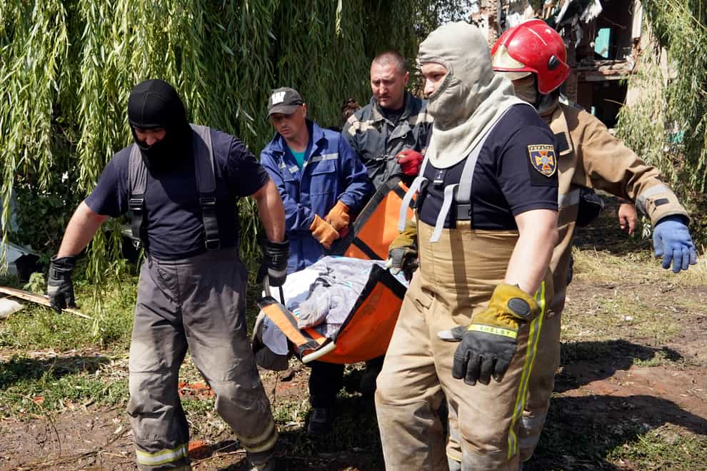 Rescuers move a covered body of a woman killed by Russian missile attack (AP)