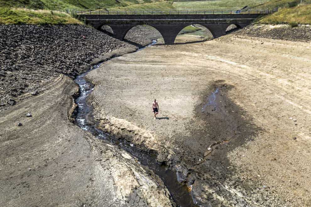 A person walks a dry bank of a tributary to the Dowry Reservoir close to Oldham (Danny Lawson/PA)