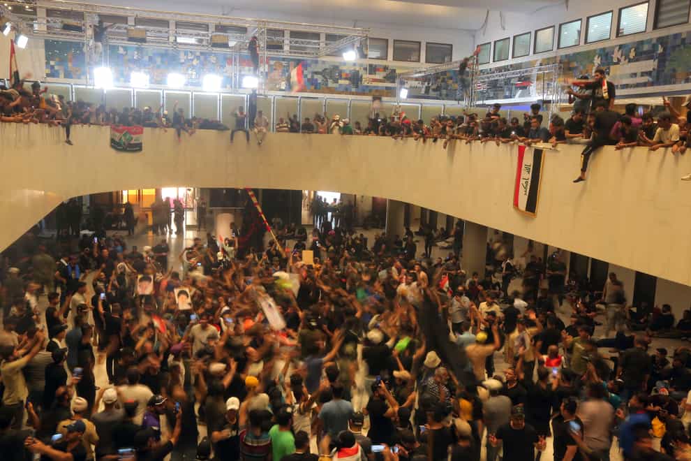Iraqi protesters fill the parliament building in Baghdad (Anmar Khalil/AP)