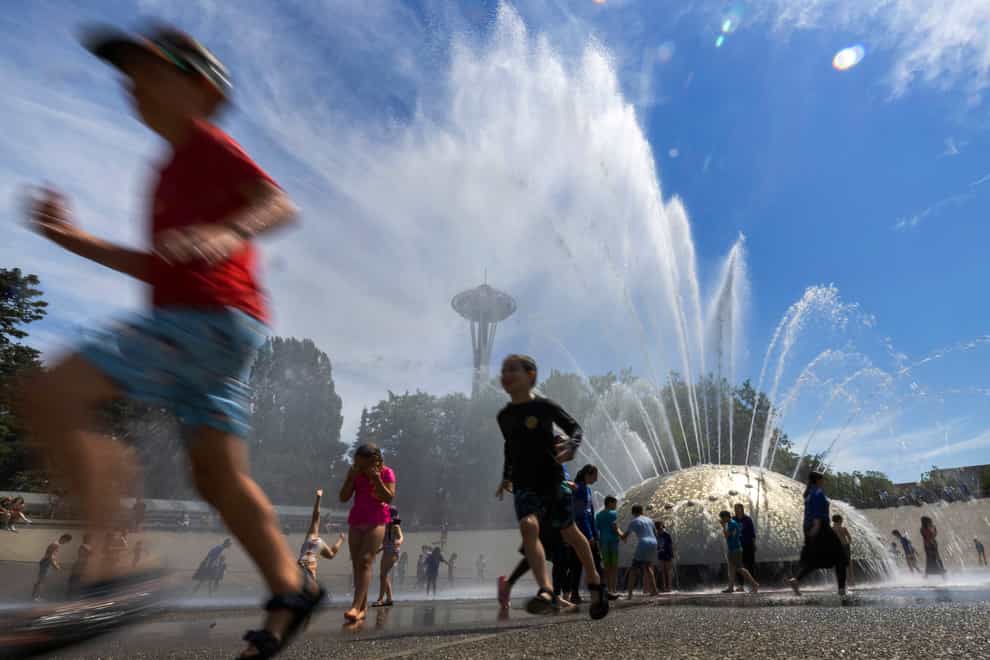 The International Fountain at Seattle Centre is packed with children amid the heatwave (Ellen M Banner/The Seattle Times/AP)