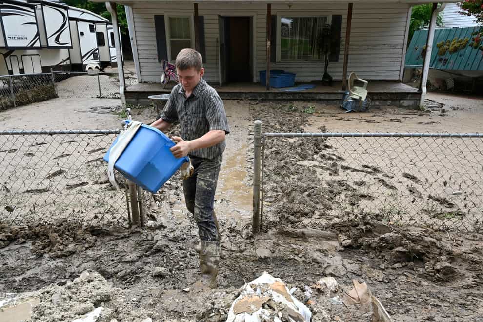 A man removes mud and debris from a home following flooding at Ogden Hollar in Hindman, Kentucky (Timothy D Easley/AP)