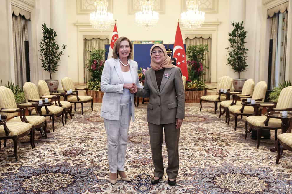 In this photo provided by Ministry of Communications and Information, Singapore, U.S. House Speaker Nancy Pelosi, left, and Singapore President Halimah Yacob shake hands at the Istana Presidential Palace in Singapore, Monday, Aug. 1, 2022. Pelosi arrived in Singapore early Monday, kicking off her Asian tour as questions swirled over a possible stop in Taiwan that has fueled tension with Beijing. (Ministry of Communications and Information, Singapore via AP)
