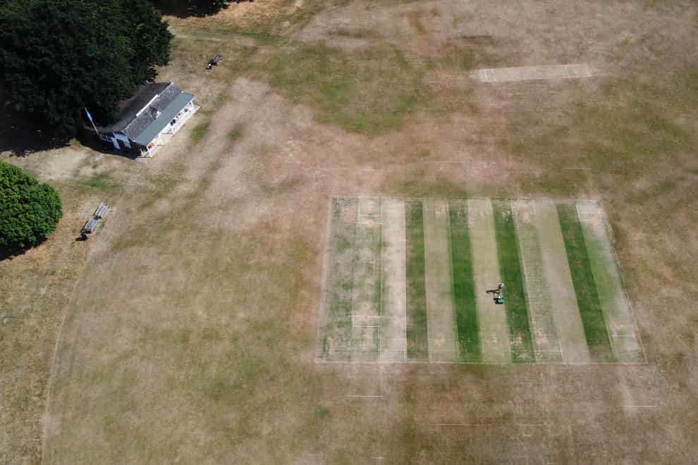 Vic Lilley, groundsman at Boughton and Eastwell Cricket Club in Ashford, Kent, prepares the wickets on a parched cricket pitch (Gareth Fuller/PA)