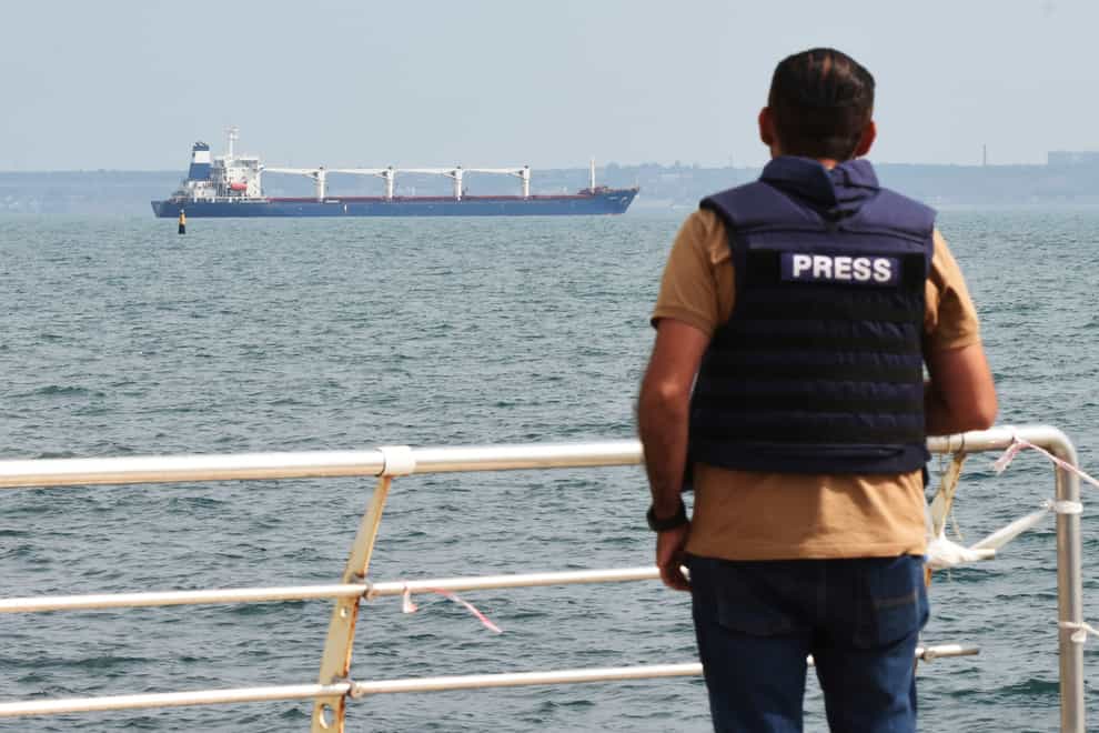 A journalist watches as the bulk carrier Razoni starts its way from the port in Odesa, Ukraine (AP)