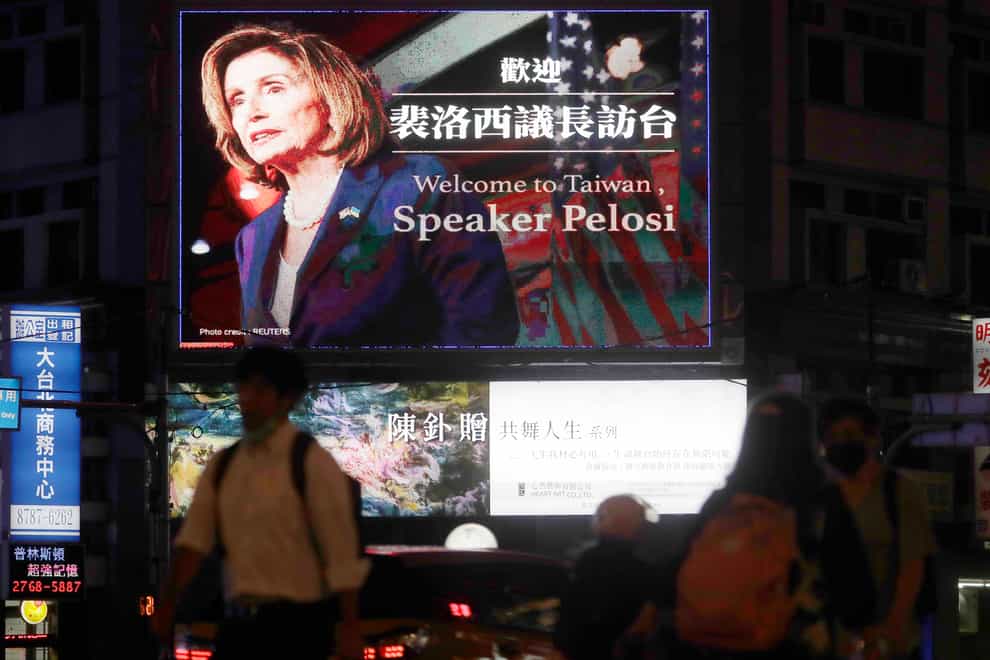 People walk past a billboard welcoming US house speaker Nancy Pelosi in Taipei (AP)