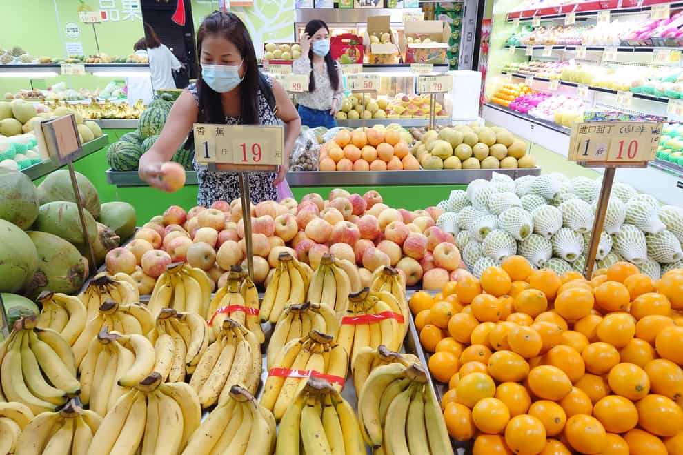Customers buy fruit at a stall in Taipei, Taiwan (Chiang Ying-ying/AP)