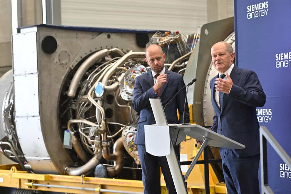 German Chancellor Olaf Scholz, right, stands beside Christian Bruch, chief executive of Siemens Energy, at the turbine serviced in Canada for the Nordstream 1 natural gas pipeline in Muelheim an der Ruhr, Germany (Bernd Thissen/dpa via AP)