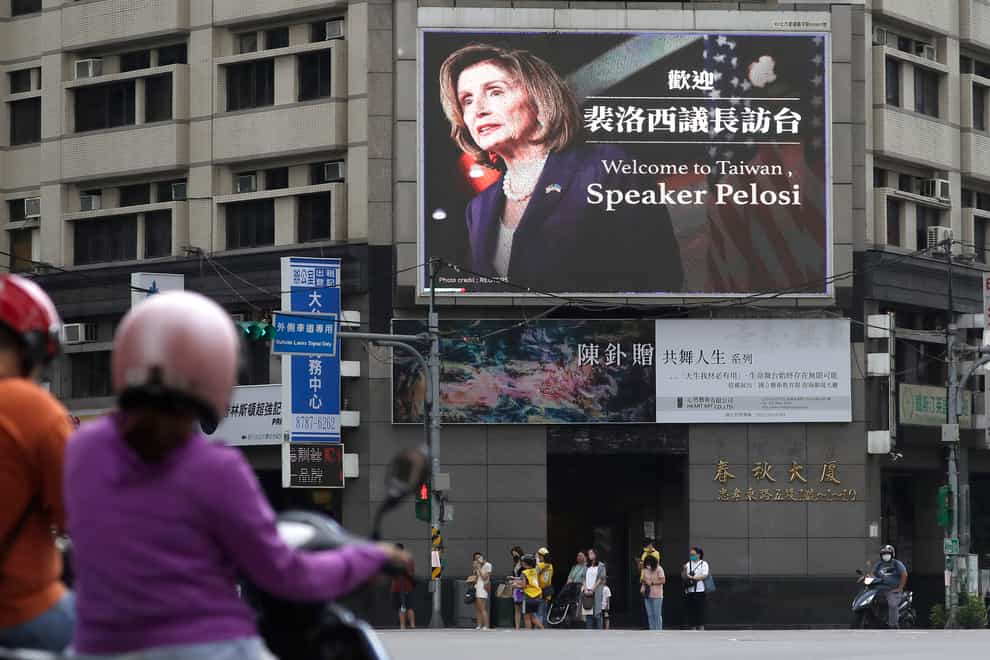 People walk past a billboard welcoming US House Speaker Nancy Pelosi in Taipei, Taiwan (Chiang Ying-ying/AP)