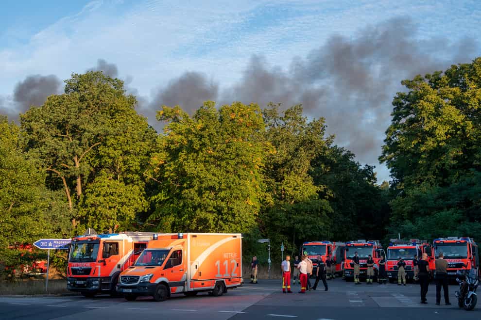 Fire engines and ambulances stand on Kronprinzessinnen Road at the Grunewald forest in Berlin, Germany (Christophe Gateau/dpa via AP)