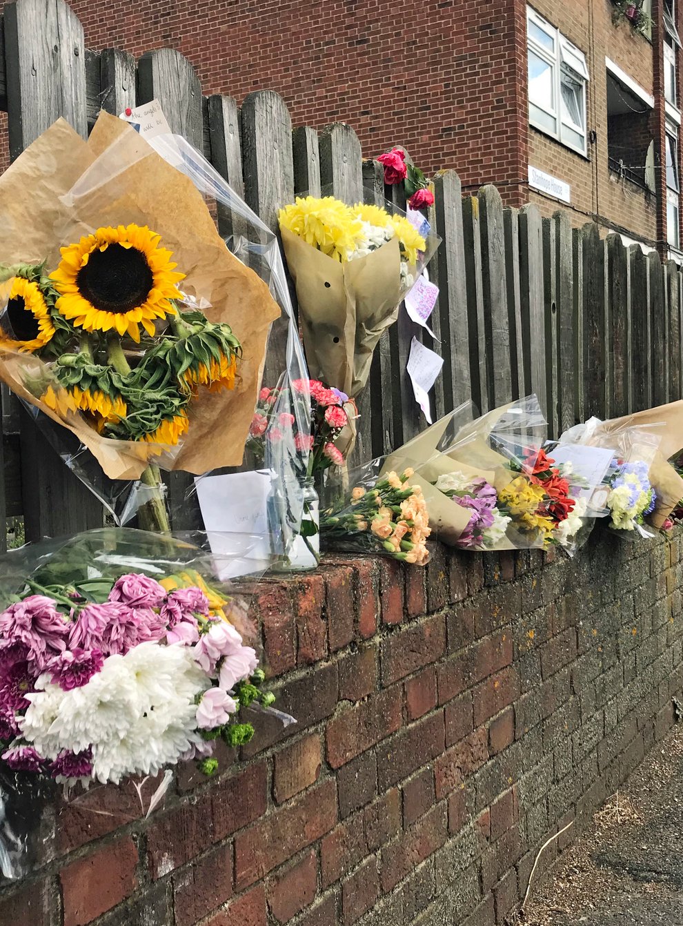 Floral tributes left on a fence near to the scene on Adolphus Street, Deptford, south-east London, where seven-year-old Joel Urhie was found dead after a blaze at his family home (Henry Vaughan/PA)