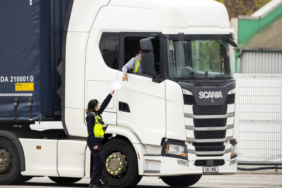 A Border Force Officer returns papers to a haulage driver after checks at Belfast Port (PA)