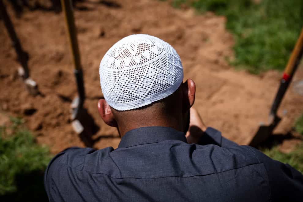 Muslim men pray over the grave of Muhammad Afzaal Hussain, 27, at Fairview Memorial Park in Albuquerque (Chancey Bush/AP)