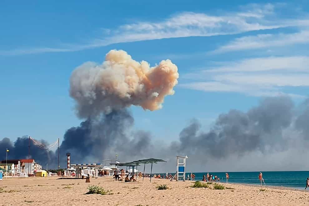 Rising smoke can be seen from the beach at Saky after explosions were heard from the direction of a Russian military airbase near Novofedorivka, Crimea, Tuesday Aug. 9, 2022. The explosion of munitions caused a fire at a military air base in Russian-annexed Crimea Tuesday but no casualties or damage to stationed warplanes, Russia’s Defense Ministry said. (UGC via AP)