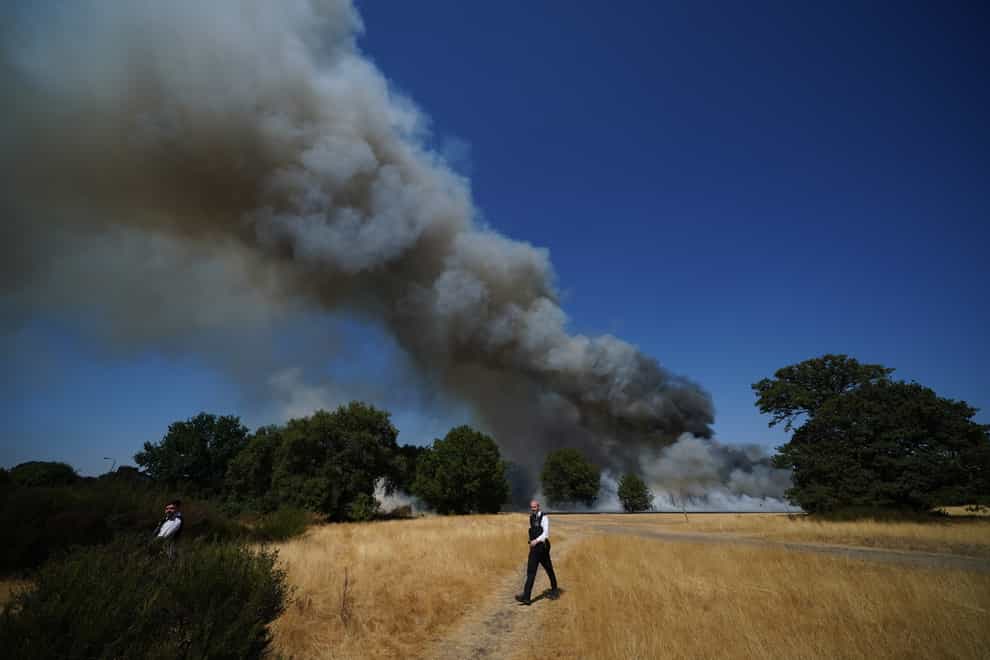 Police officers near the scene of a grass fire at the Leyton Flats nature reserve in east London (Yui Mok/PA)
