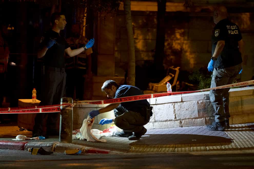Israeli police crime scene investigators work at the scene of a shooting attack that wounded several Israelis near the Old City of Jerusalem (Maya Alleruzzo/AP)