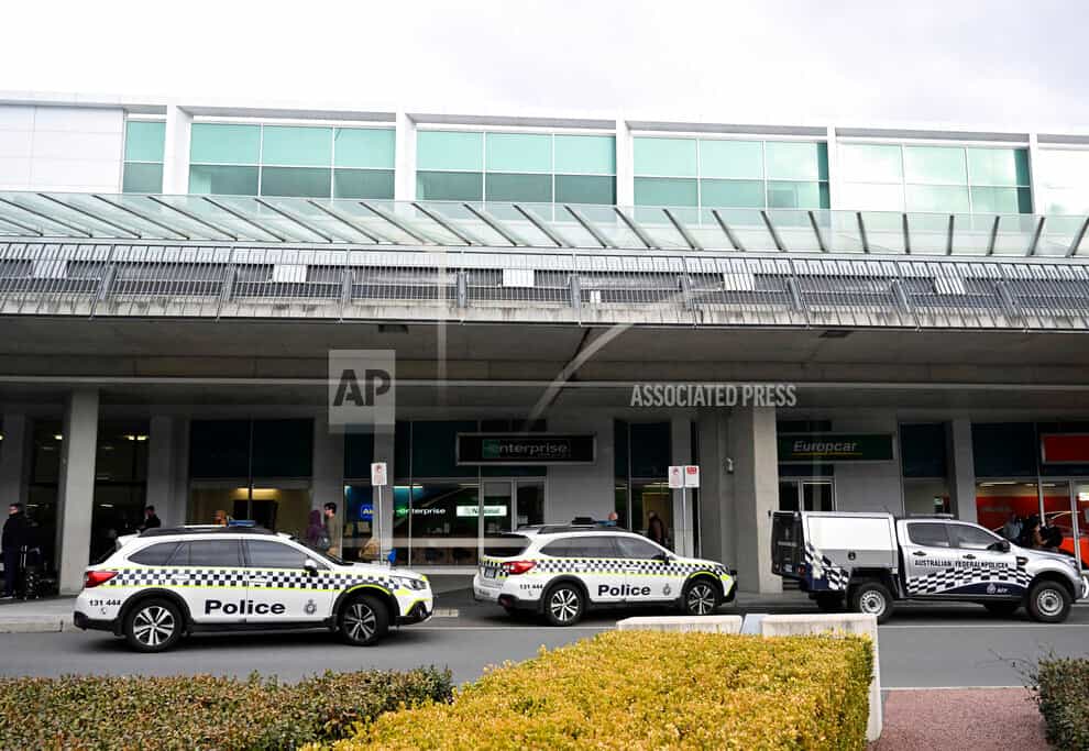 Australian Federal Police attend the Canberra Airport in Canberra, Sunday, Aug. 14, 2022, after a shooting incident. An Australian man is charged with three weapons offenses Monday, Aug. 15, after he allegedly used a handgun inside the Canberra Airport to fire multiple shots at airport windows. (Mick Tsikas/AAP Image via AP)