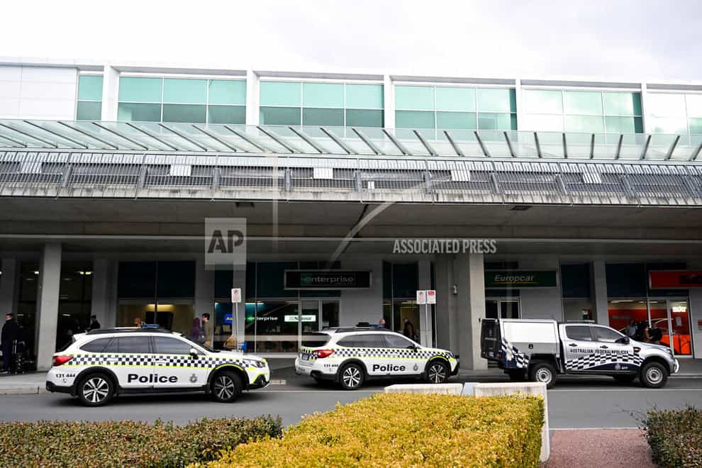 Australian Federal Police attend the Canberra Airport in Canberra, Sunday, Aug. 14, 2022, after a shooting incident. An Australian man is charged with three weapons offenses Monday, Aug. 15, after he allegedly used a handgun inside the Canberra Airport to fire multiple shots at airport windows. (Mick Tsikas/AAP Image via AP)